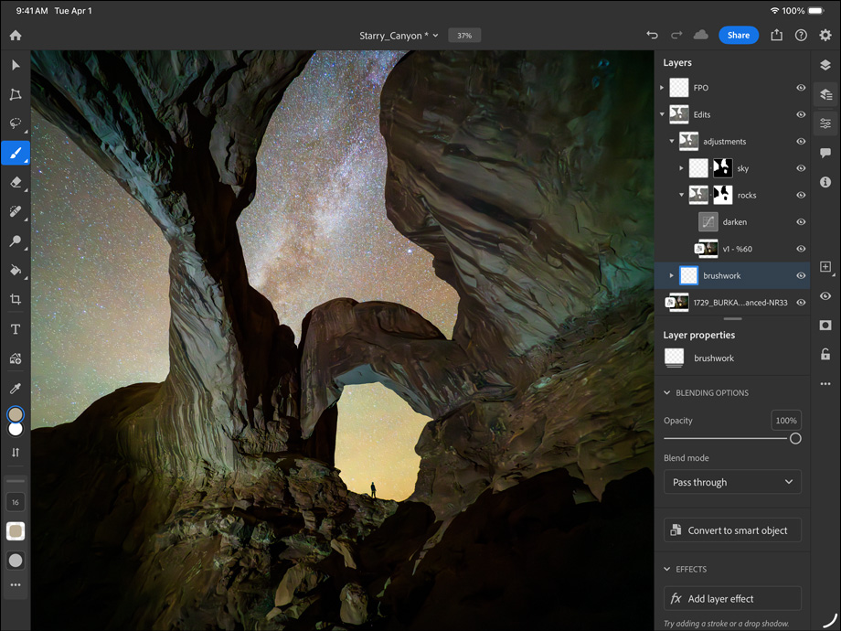 iPad Pro, face avant, orientation paysage, noir sidéral, angles arrondis, cadre d’écran noir, écran affichant la retouche d’une photo d’un canyon et d’un ciel étoilé, avec sur la droite, calques de retouche, outils et effets visibles, notamment pinceau, réglages et autres